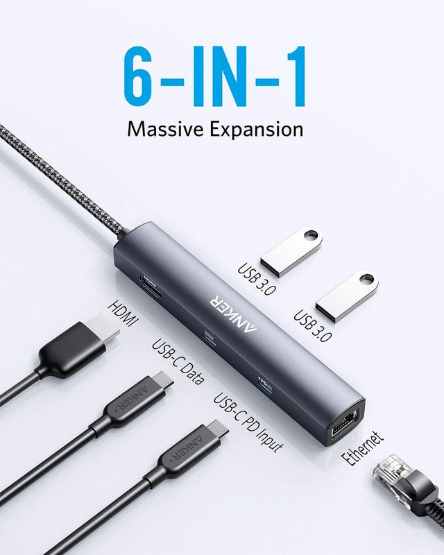 Anker 543 USB-C Hub in grey showing multiple ports for charging and connectivity, slim 6-in-1 design on a neutral background.