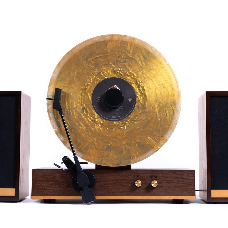 Fuse Audio GLD Vertical Vinyl Record Player, turntable with gold finish, featuring a sleek vertical design and tonearm for vinyl playback.
